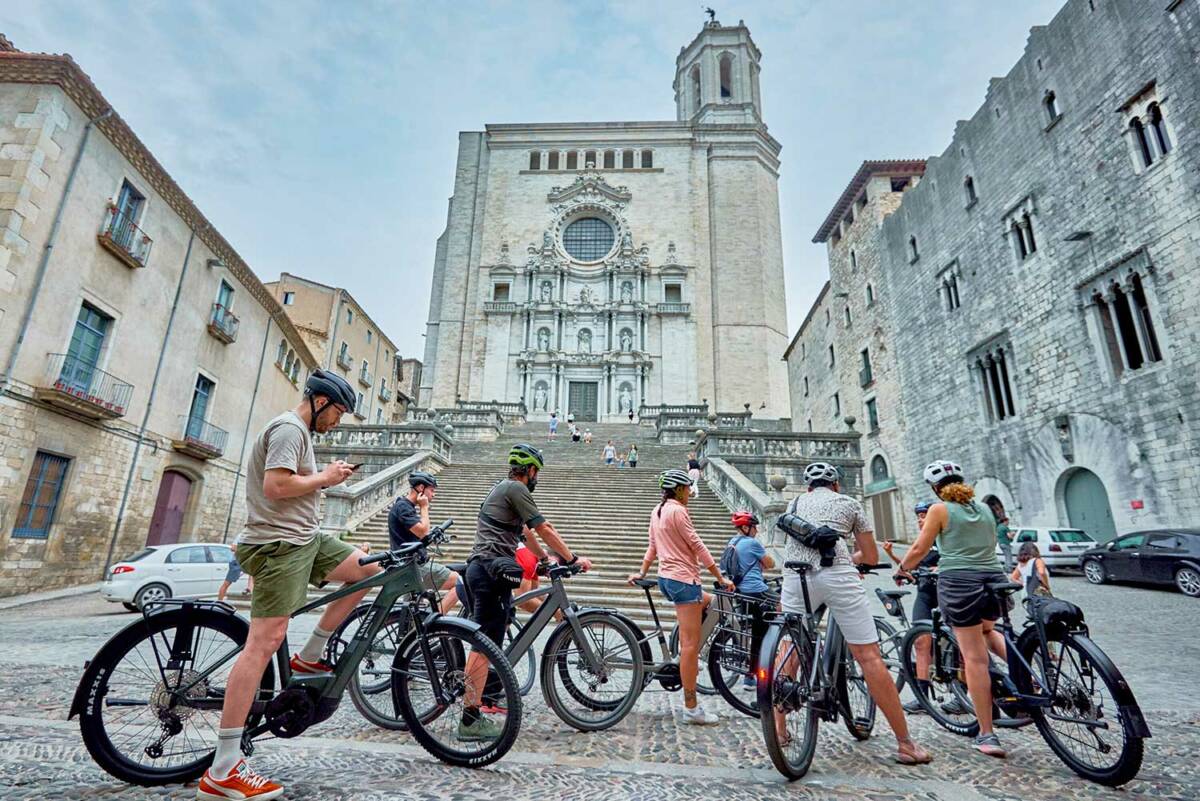 Close-up of several cyclists who are doing a tourist route and have made a stop in front of the cathedral of Girona taking advantage of their visit to the Sea Otter Europe festival