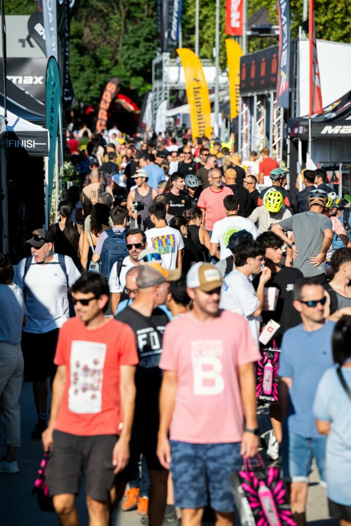 Multitud de visitantes que pasean por la zona roja dentro de la exposición de marcas de bicicletas en el festival internacional Sea Otter Europe
